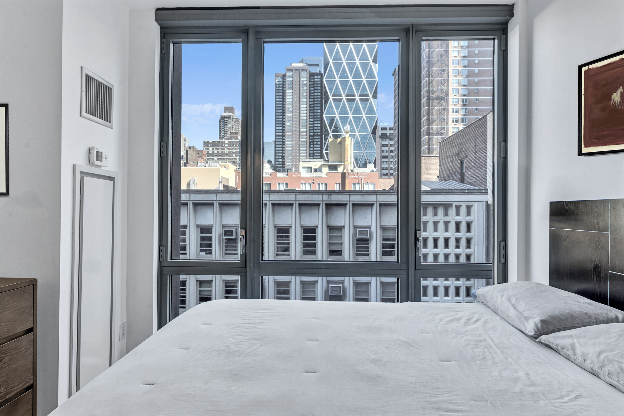 310 West 52nd Street, Unit 5F Manhattan, NY 10019 - Photo 6 of 13 a bedroom with a bed next to a window