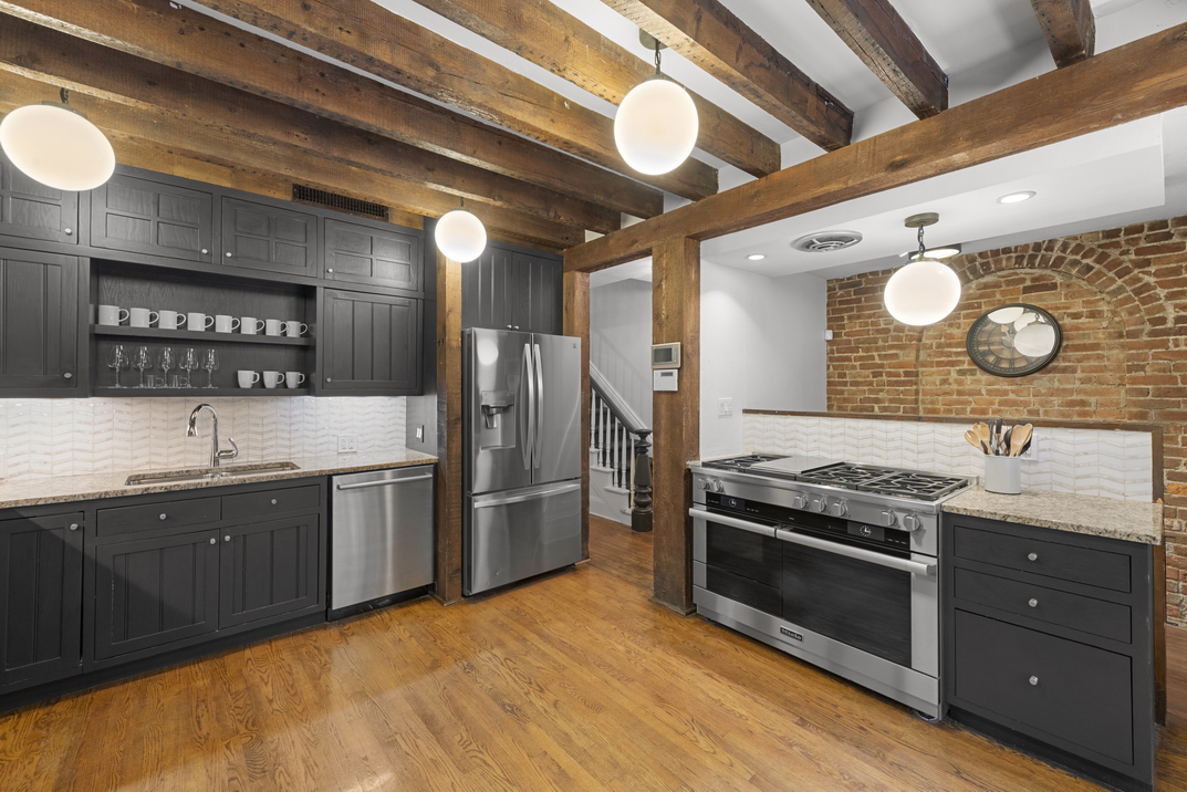 209 East 61st Street Manhattan, NY 10065 - Photo 22 of 27 a kitchen with stainless steel appliances granite countertop a stove a sink and a refrigerator