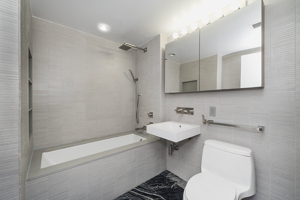 250 Bedford Avenue, Unit 129203 Brooklyn, NY 11249 - Photo 4 of 10 a bathroom with a toilet sink and shower