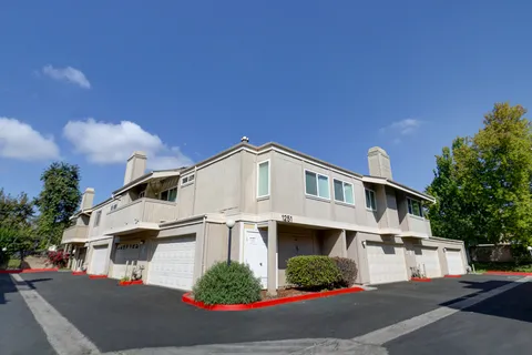 a front view of a house with garage and parking
