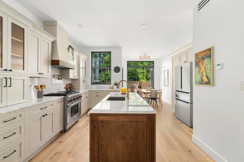 a kitchen with stainless steel appliances granite countertop a refrigerator a stove a sink dishwasher and white cabinets with wooden floor