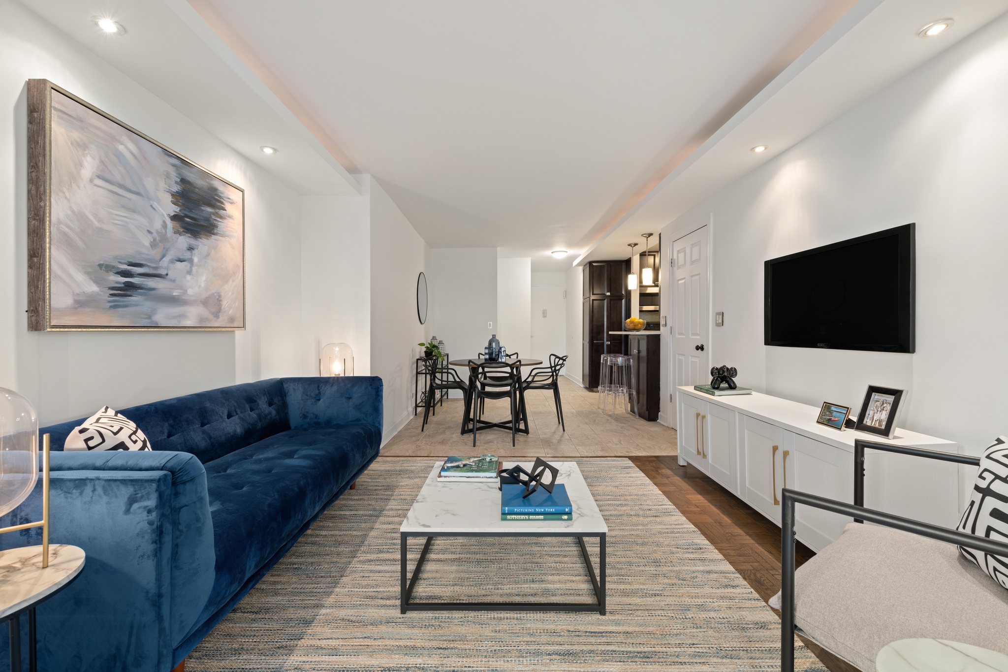 201 East 21st Street, Unit 1A Manhattan, NY 10010 - Photo 2 of 10 a living room with furniture and a flat screen tv