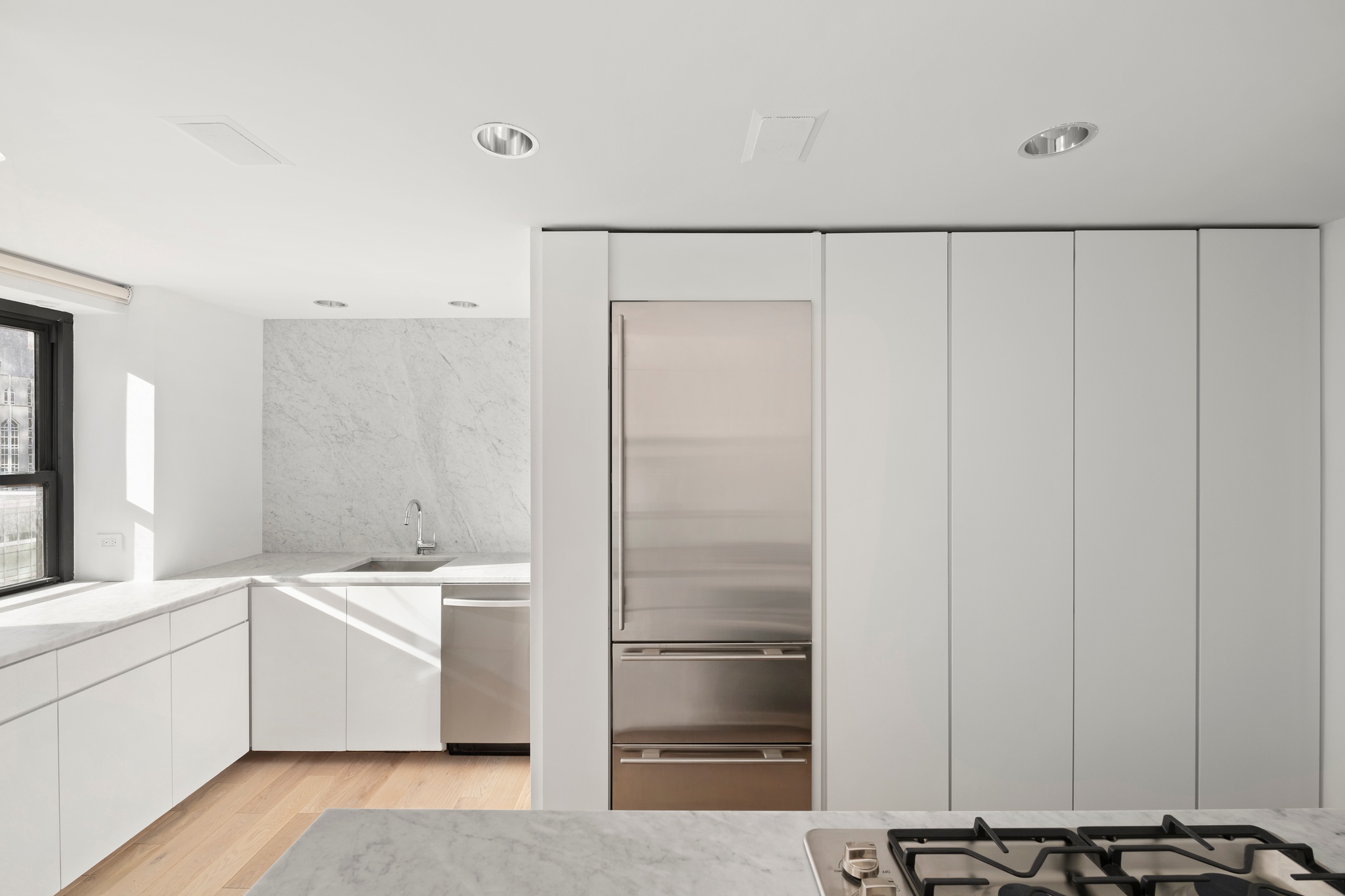 530 East 72nd Street, Unit 14E Manhattan, NY 10021 - Photo 10 of 19 a kitchen with a refrigerator and white cabinets