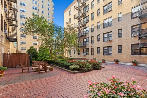 a front view of a building with garden and seating area