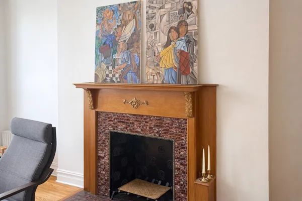 a living room with a fireplace wooden floor and a rug