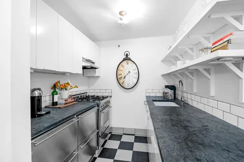 a kitchen with stainless steel appliances granite countertop a stove a sink and a cabinets