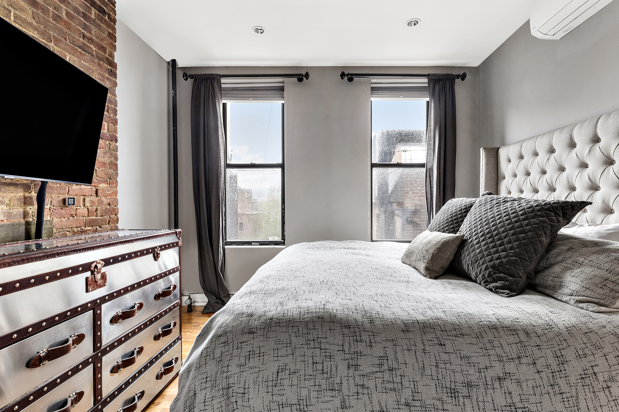 167 Grand Street, Unit 2 Brooklyn, NY 11249 - Photo 3 of 7 a bedroom with a large bed and a flat screen tv