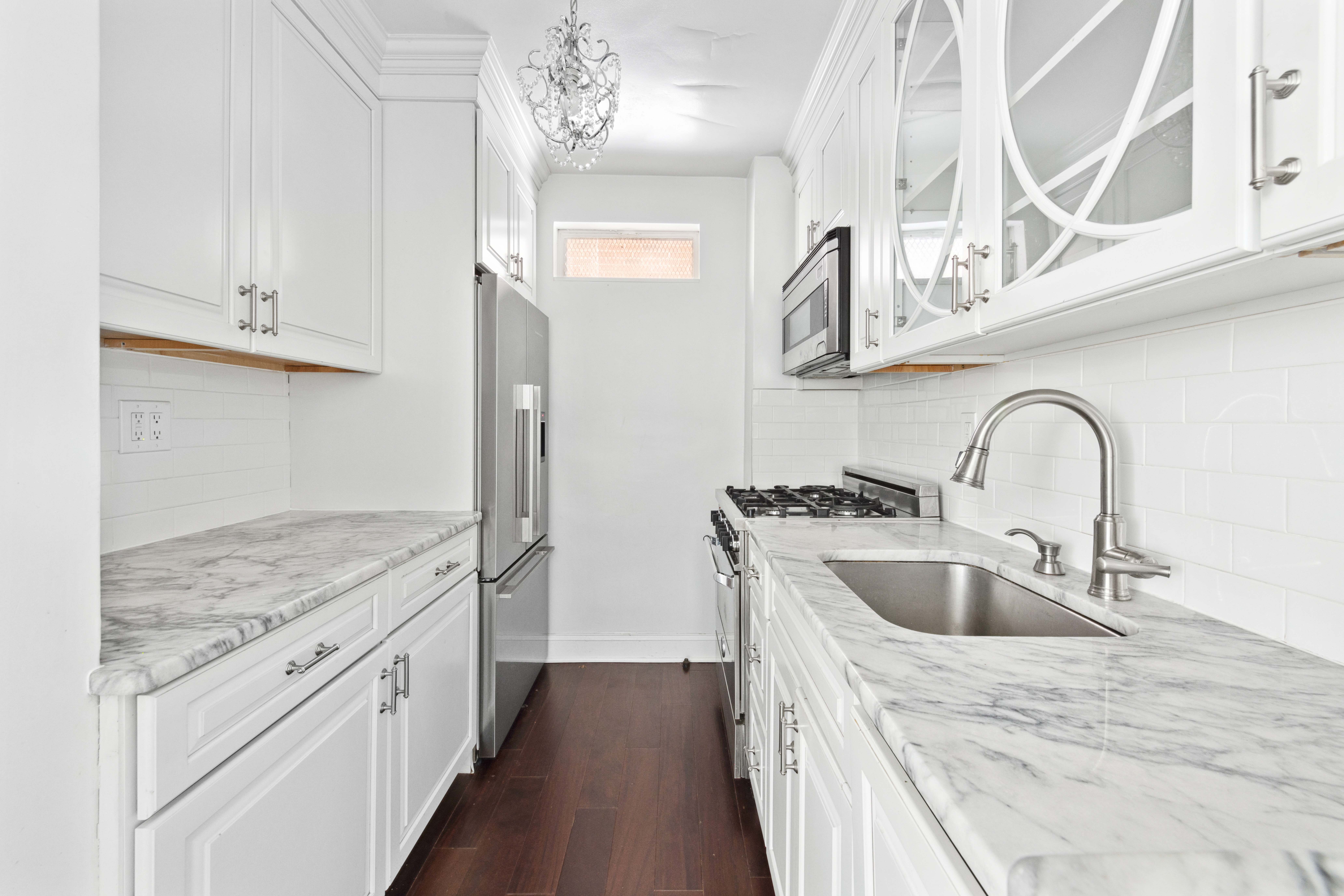 233 East 70th Street, Unit 11P Manhattan, NY 10021 - Photo 3 of 15 a kitchen with stainless steel appliances granite countertop a sink stove and refrigerator