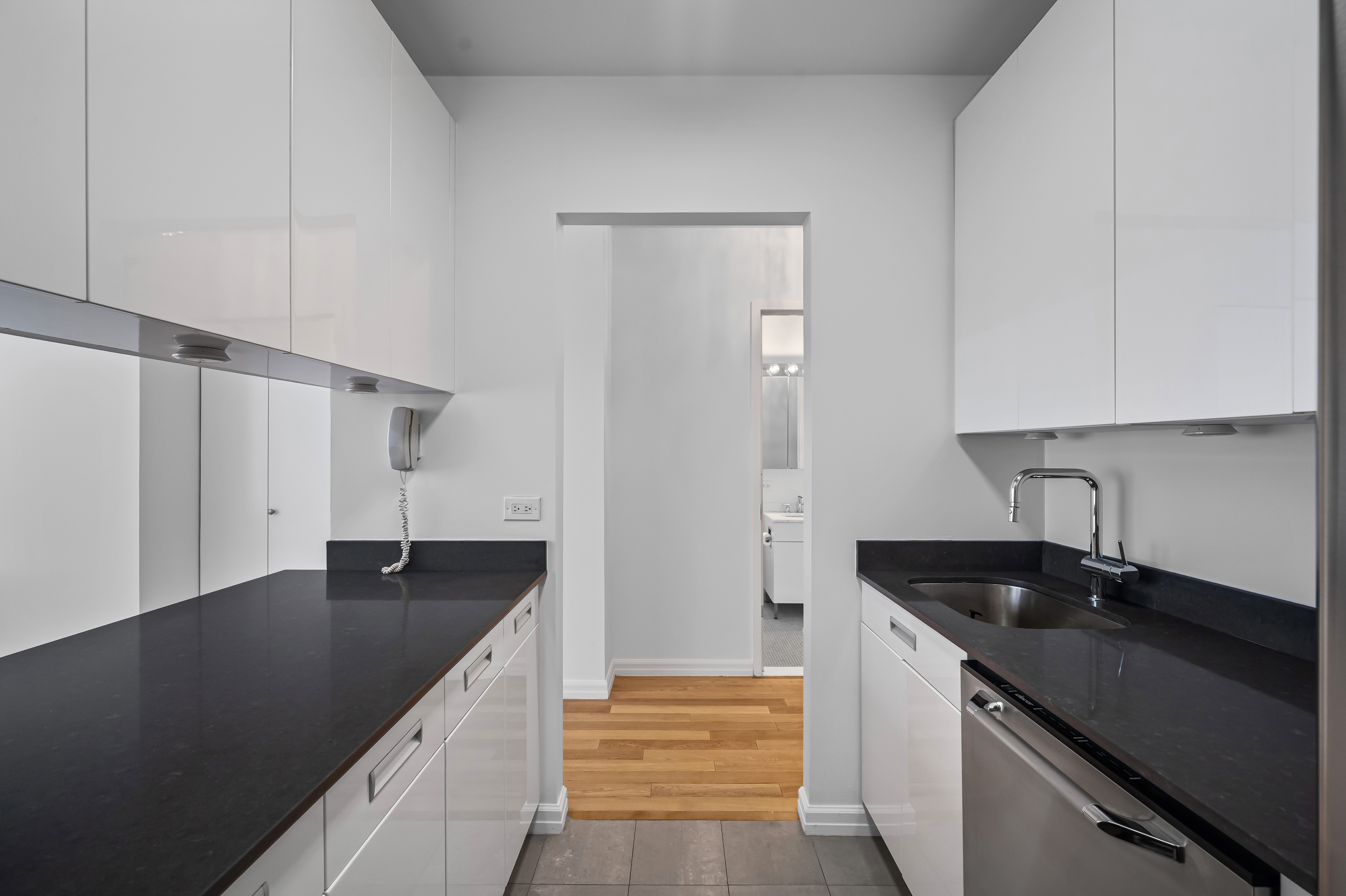 99 John Street, Unit 920 Manhattan, NY 10038 - Photo 4 of 18 a kitchen with a sink and cabinets