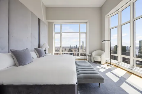 a large bedroom with a bed and a large window