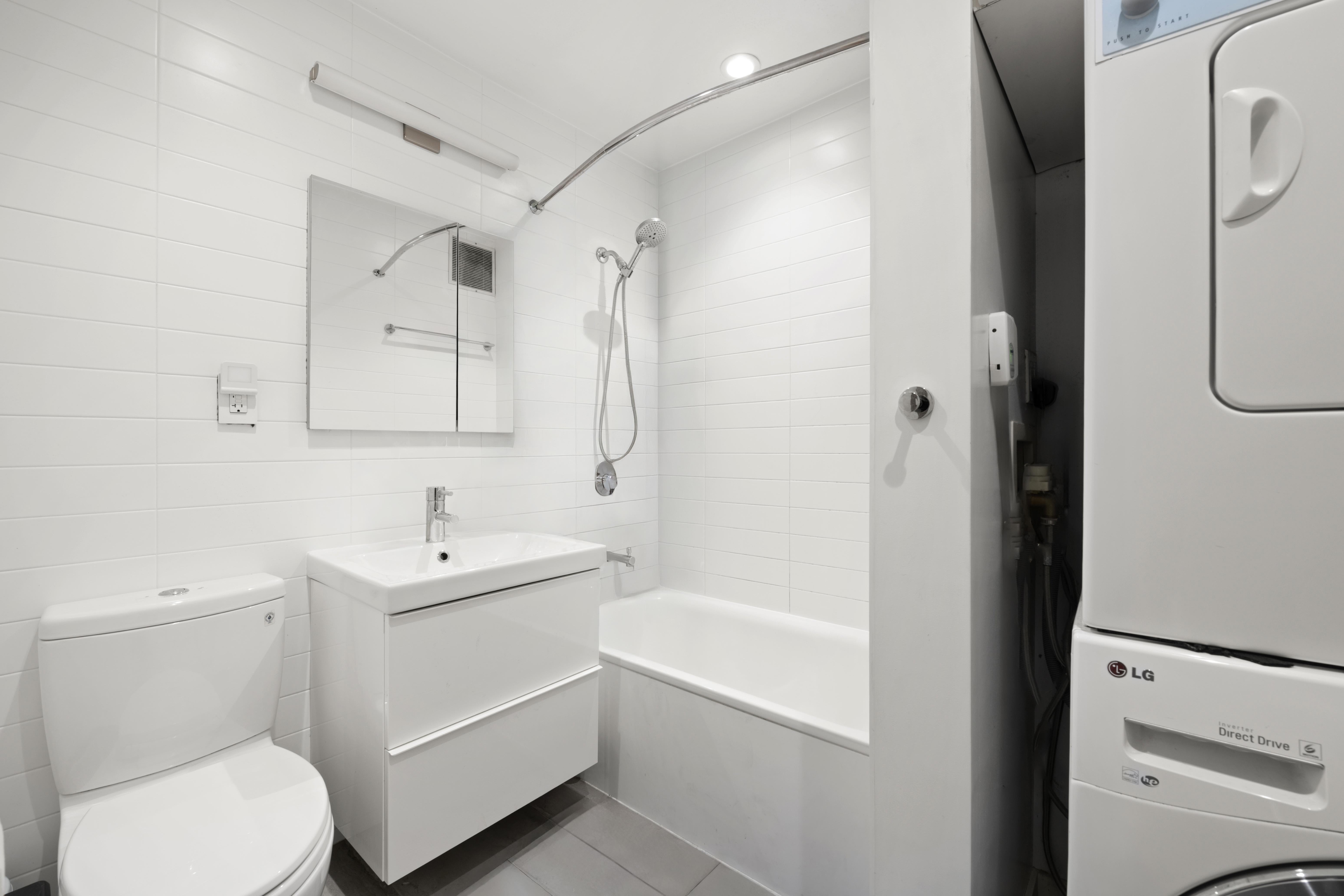 221 East 50th Street, Unit 6D/7D Manhattan, NY 10022 - Photo 15 of 19 a bathroom with a white toilet sitting next to a bathroom sink and a shower