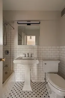 a bathroom with a sink a toilet and a mirror