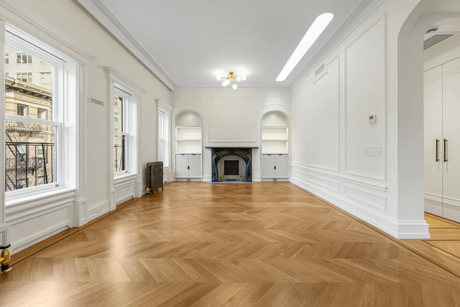 a view of empty room with fireplace and wooden floor