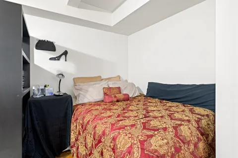a bed sitting in a bedroom next to a lamp