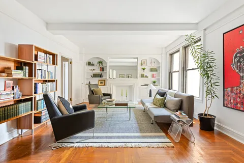 a living room with furniture fireplace and a large window