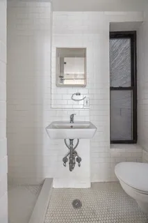 a bathroom with a sink a toilet and mirror