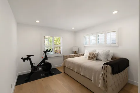 a bedroom with a bed and wooden floor