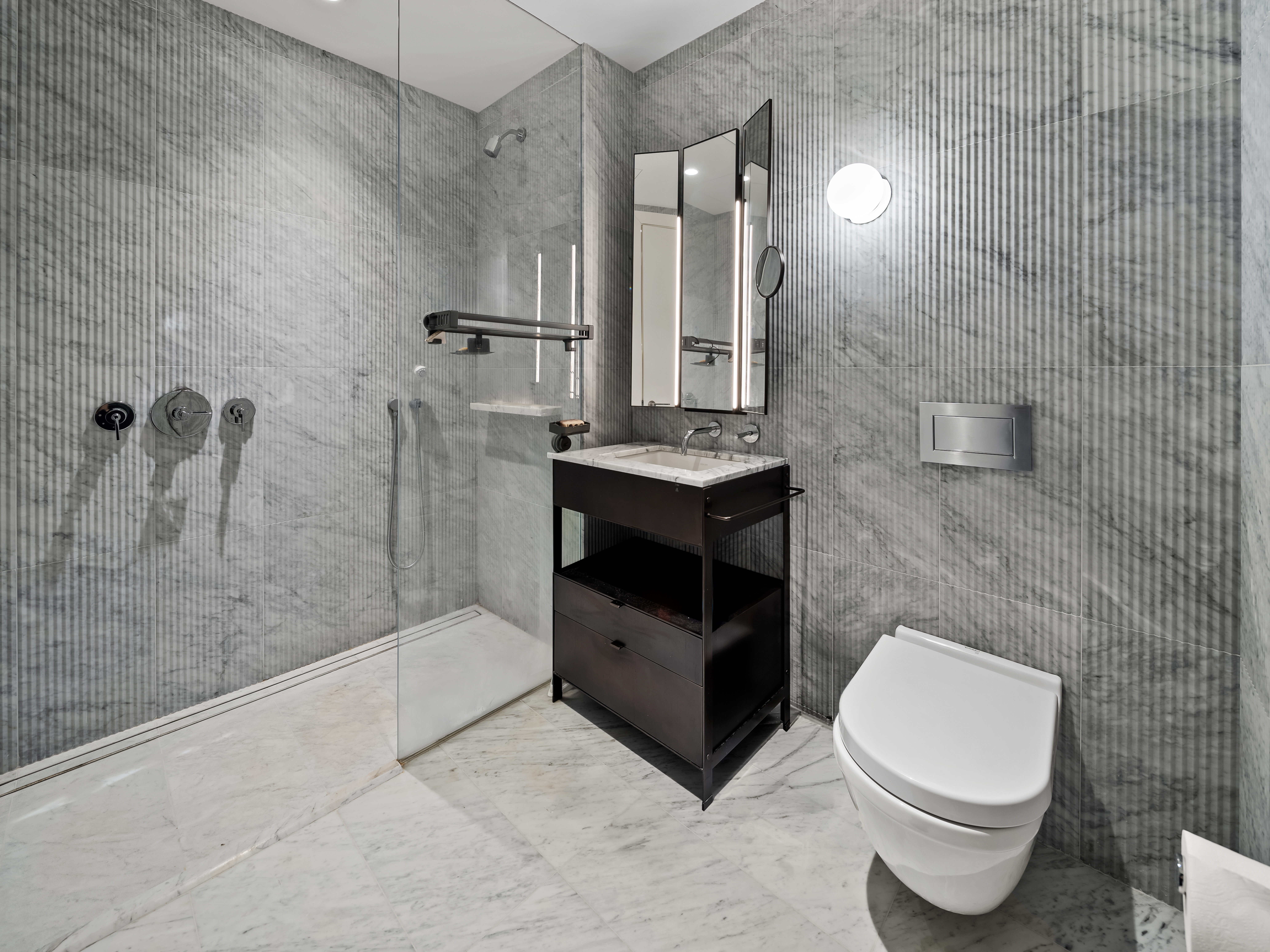 135 East 47th Street, Unit 4F Manhattan, NY 10017 - Photo 8 of 11 a bathroom with a sink a toilet and shower