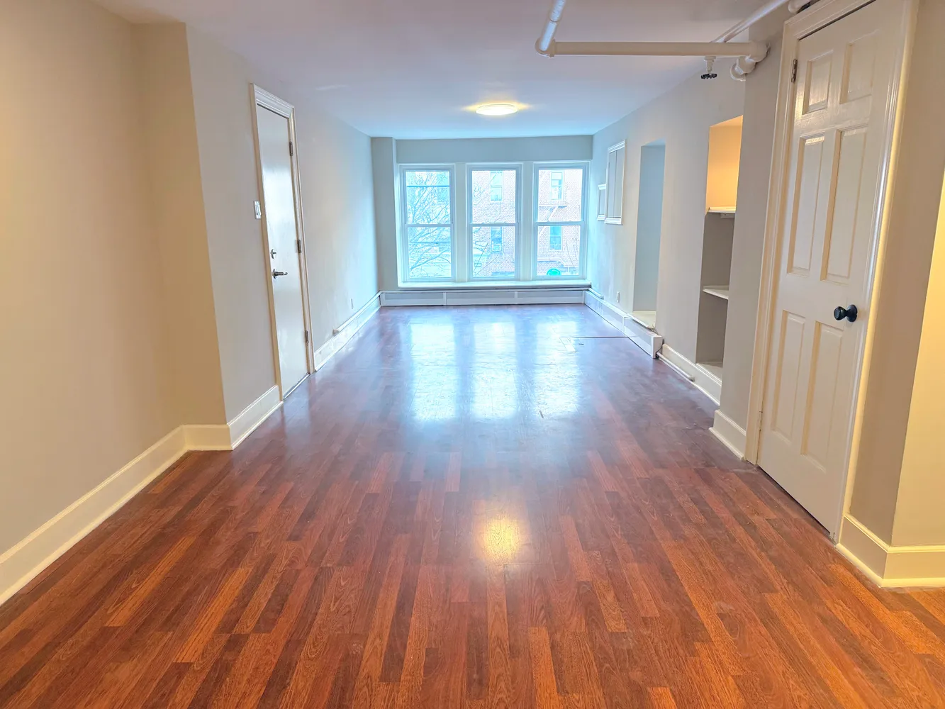 wooden floor in an empty room with a window