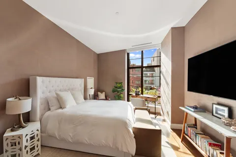 a bedroom with a bed and a flat screen tv