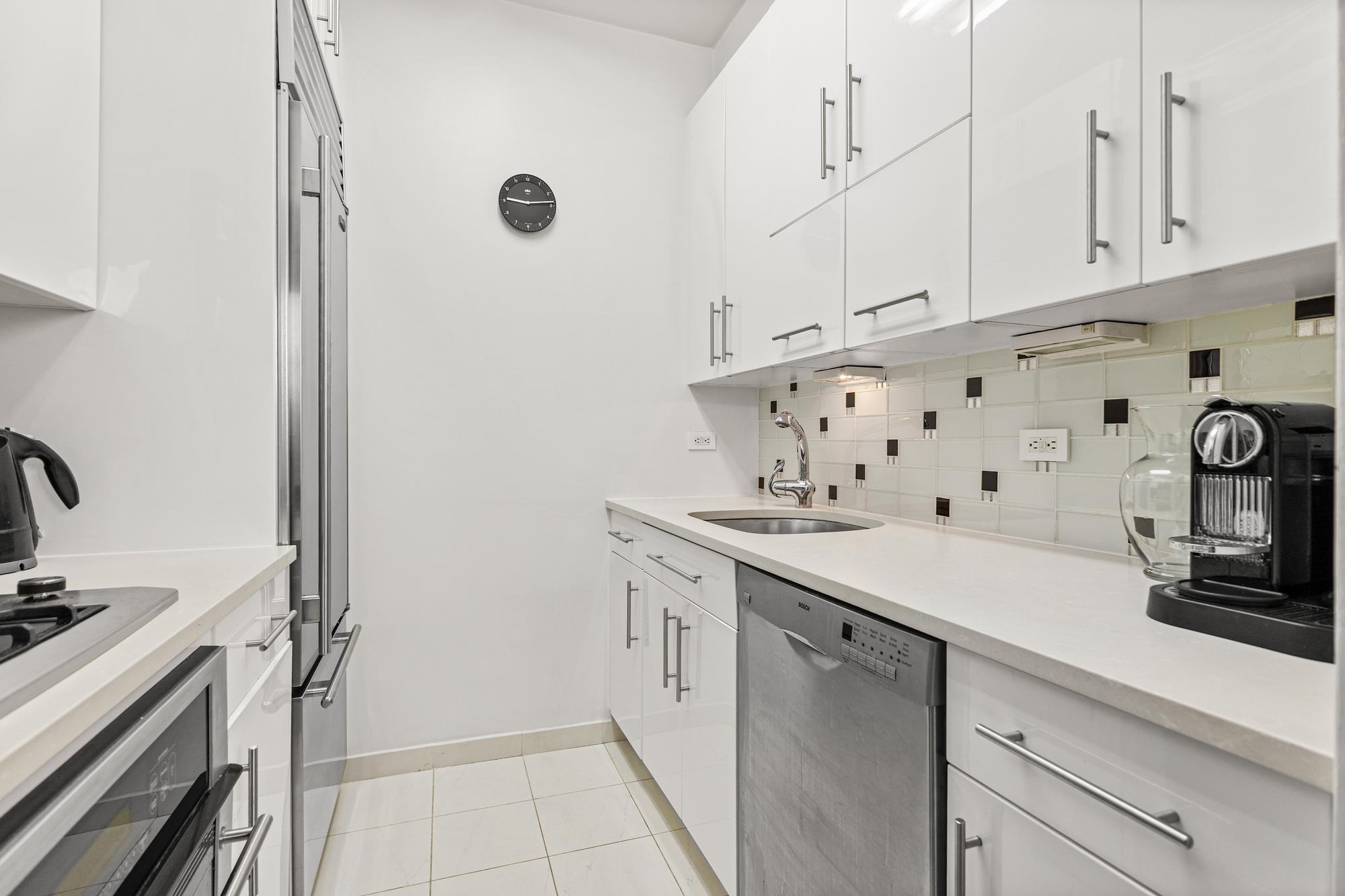 167 East 61st Street, Unit 20E Manhattan, NY 10065 - Photo 15 of 24 a kitchen with a sink stove and cabinets