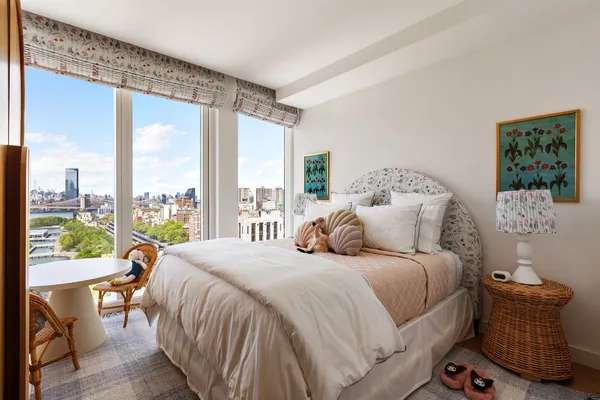 a bedroom with a bed a dresser with wooden floor