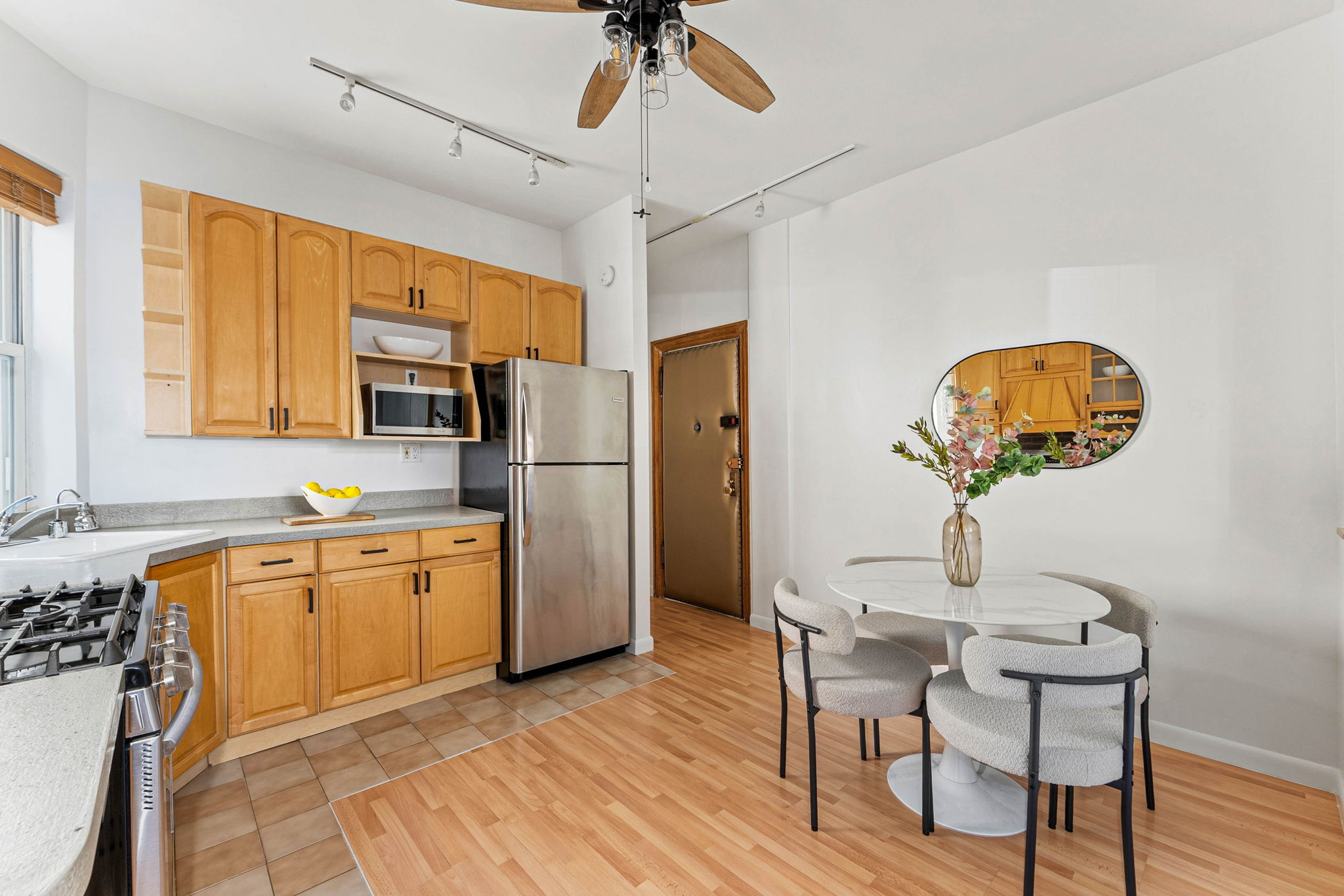 826 43rd Street, Unit 1 Brooklyn, NY 11232 - Photo 8 of 12 a kitchen with stainless steel appliances granite countertop a refrigerator a sink dishwasher a stove and a dining table with wooden floor
