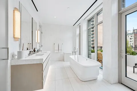 a spacious bathroom with a bathtub a sink and a large mirror