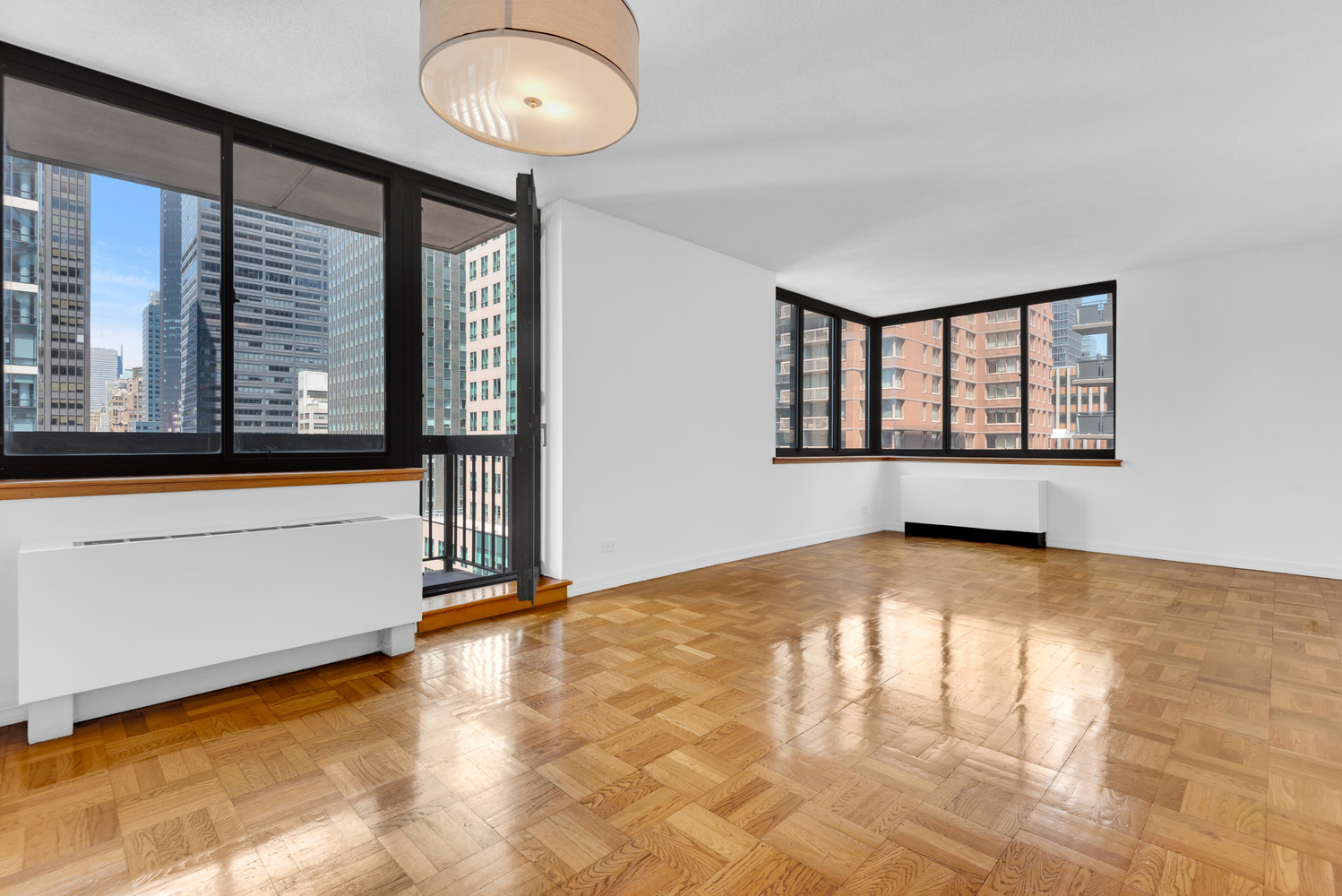 250 East 40th Street, Unit 22B Manhattan, NY 10016 - Photo 4 of 13 a view of an empty room with a window and a kitchen area