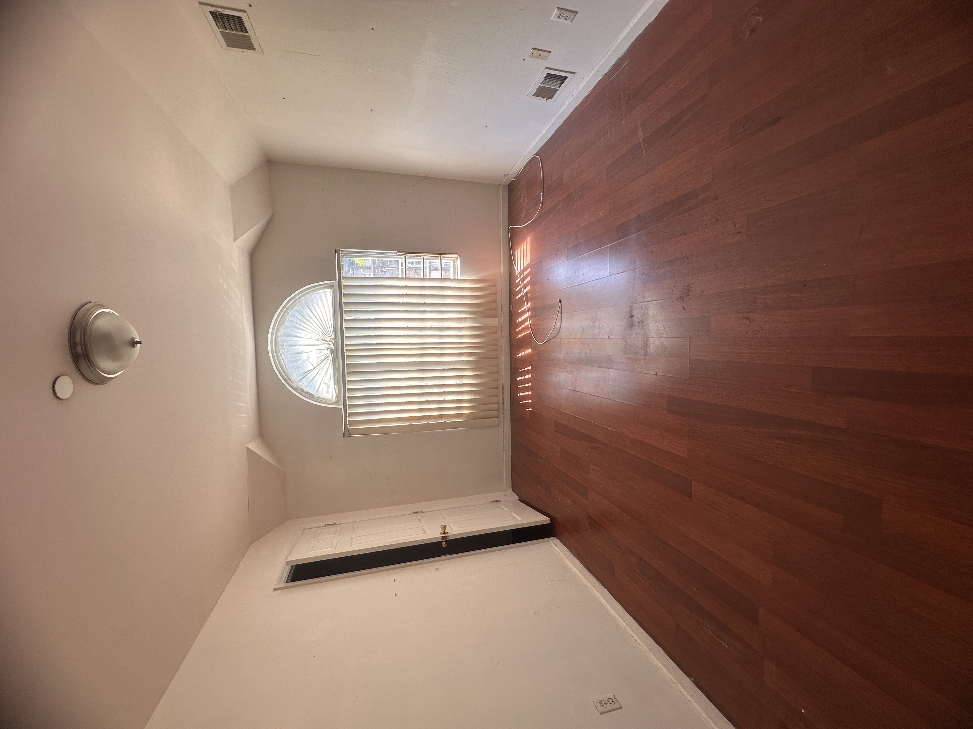 165 Brighton Avenue Staten Island, NY 10301 - Photo 6 of 8 an empty room with wooden floor and windows