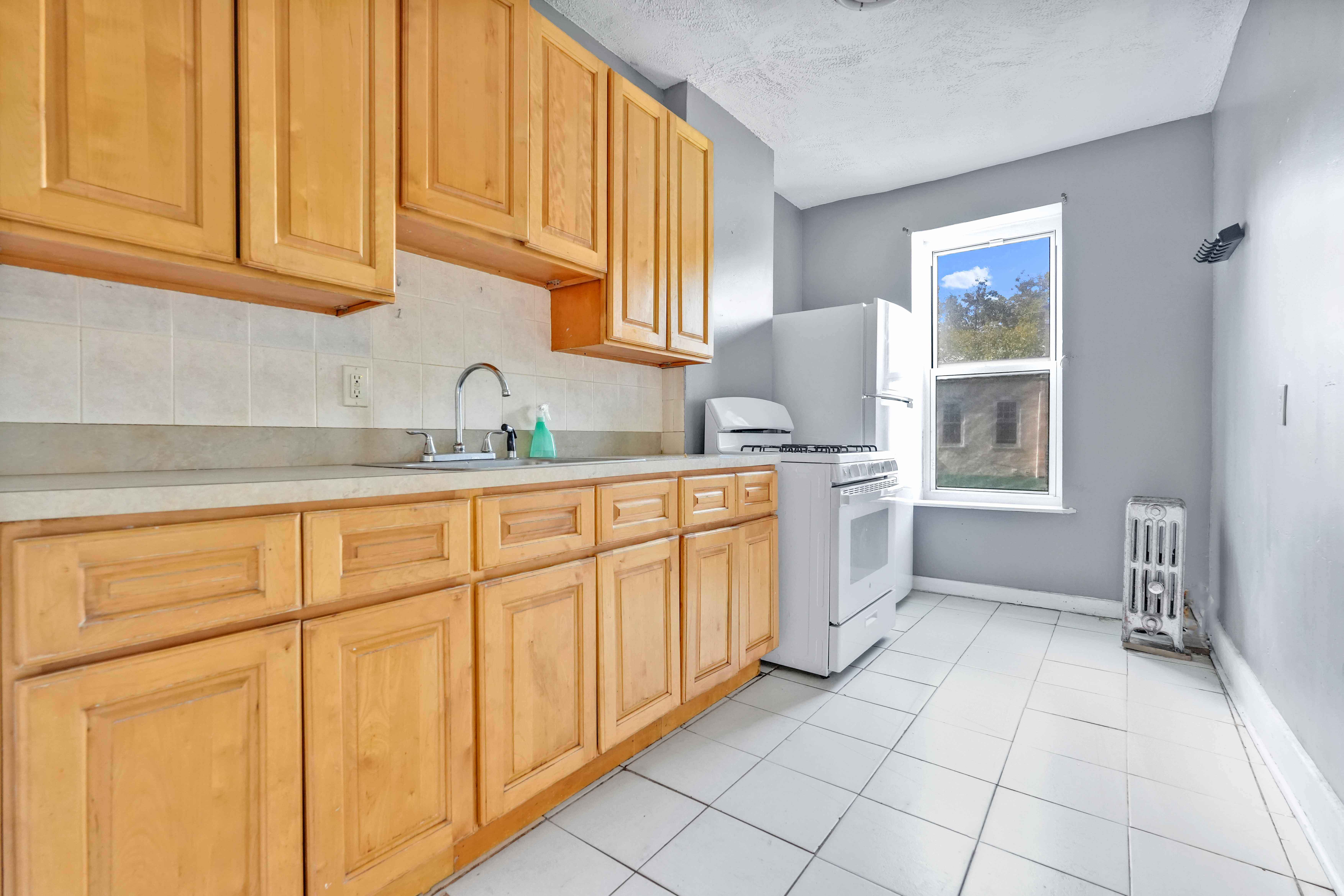 610 Ashford Street Brooklyn, NY 11207 - Photo 9 of 28 a kitchen with white cabinets and sink