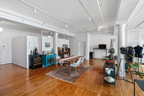 a living room with furniture large window and wooden floor