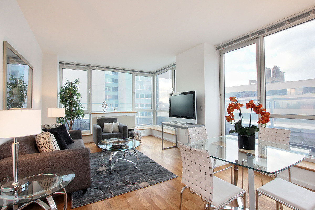a living room with furniture a flat screen tv and a large window