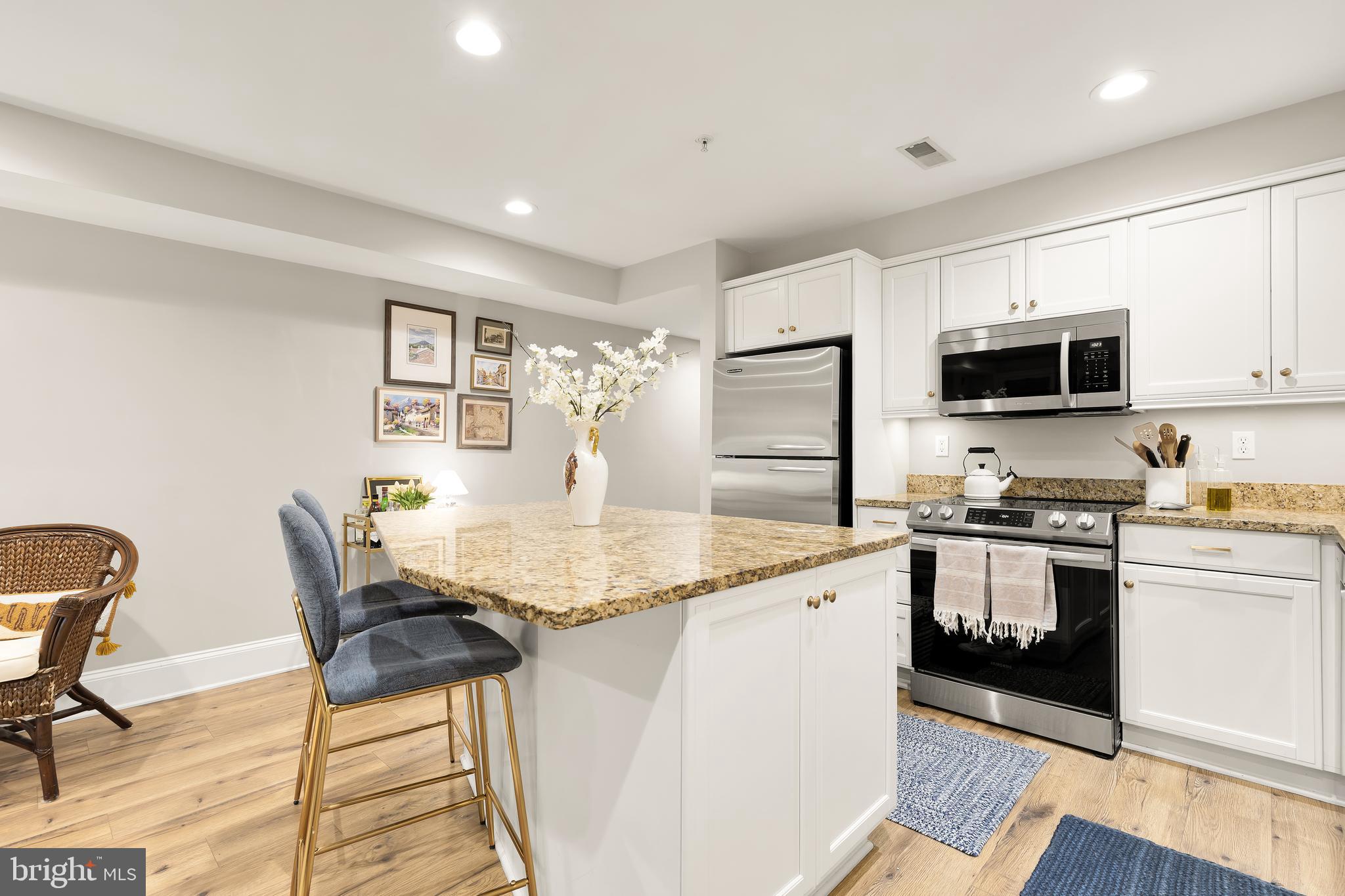 1354 Kenyon Street Northwest, Unit G Washington, DC 20010 - Photo 12 of 37 a kitchen with stainless steel appliances granite countertop a stove a sink a microwave a dining table and chairs