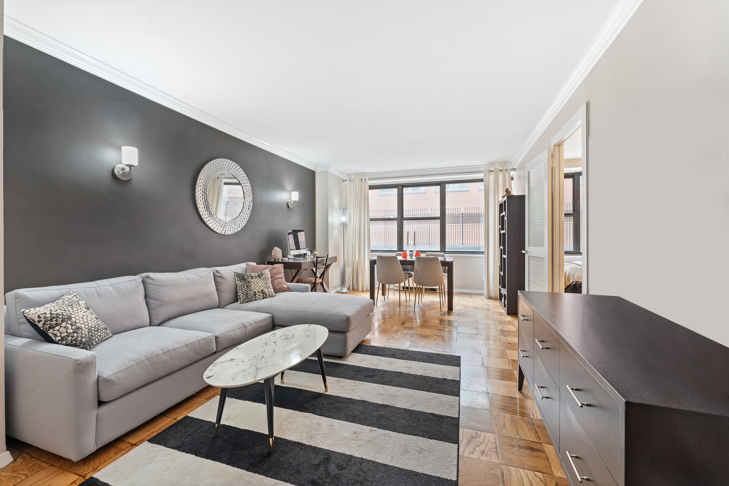 a living room with furniture wooden floor and a large window