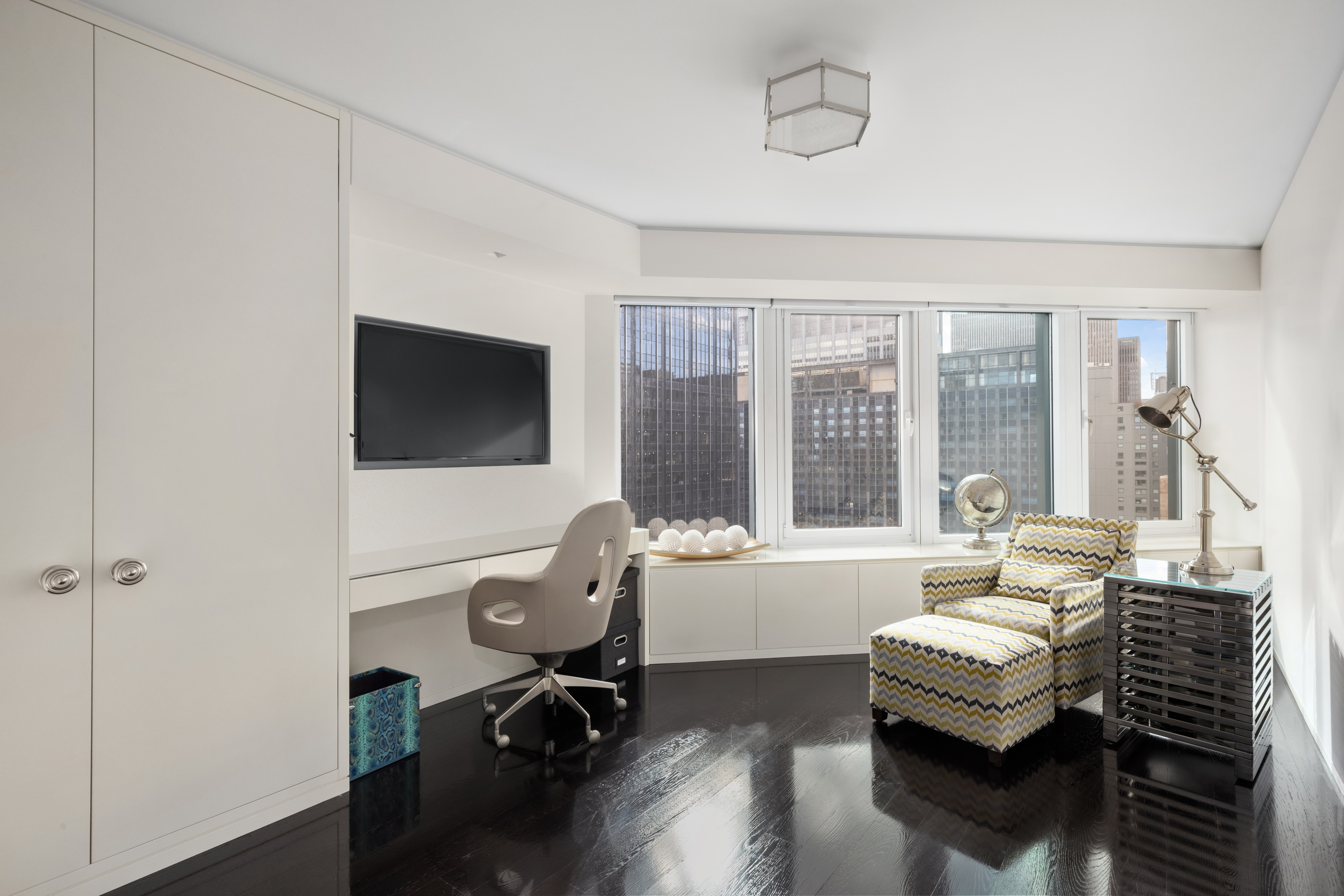 150 West 56th Street, Unit 3901 Manhattan, NY 10019 - Photo 13 of 25 a living room with furniture and a flat screen tv