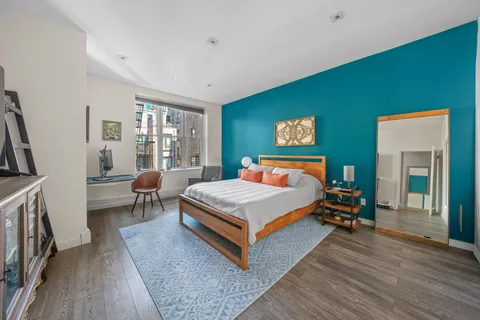 a bedroom with a bed lamp closet and large window