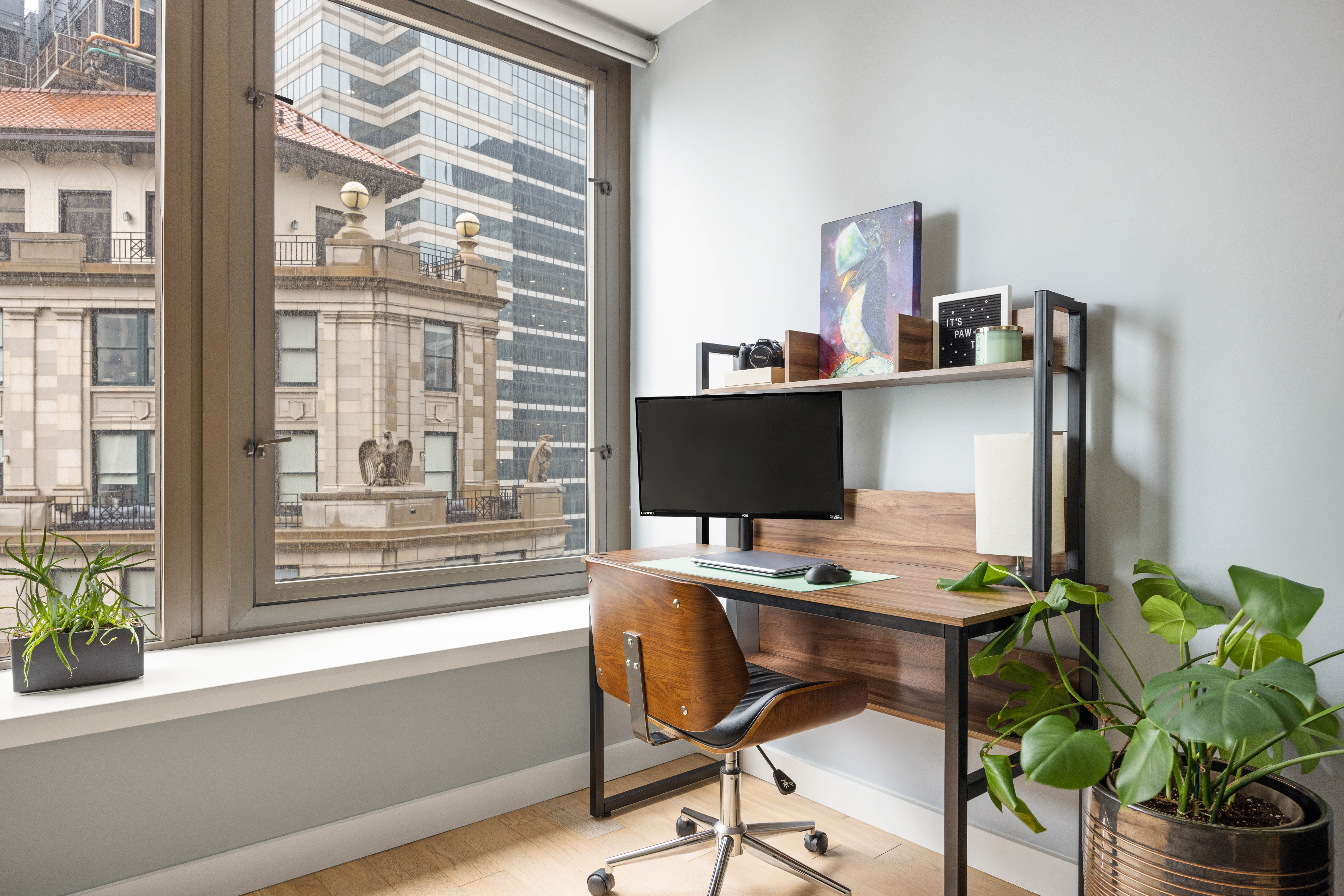 75 Wall Street, Unit 25K Manhattan, NY 10005 - Photo 2 of 9 a workspace with furniture and a potted plant
