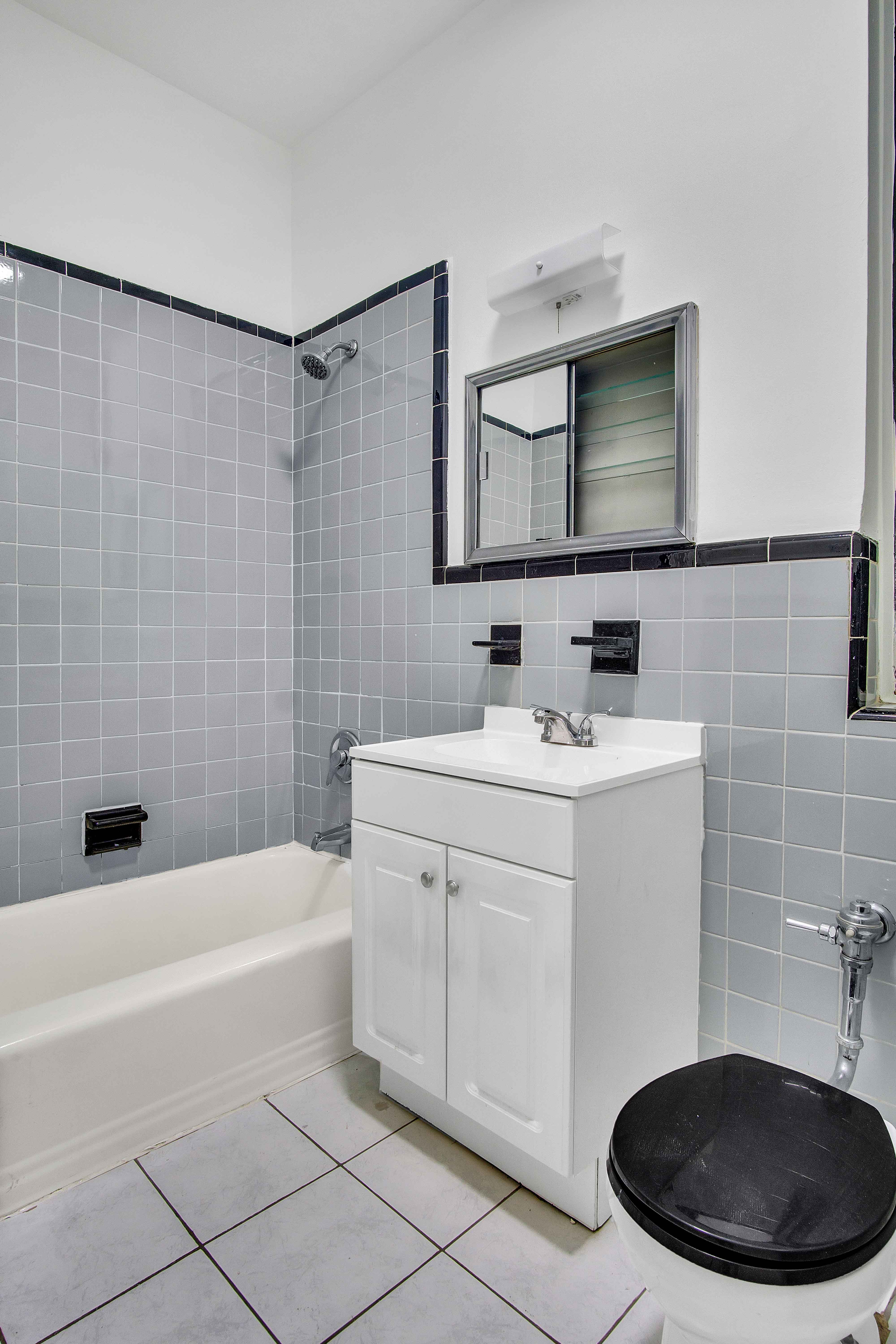 348 West 56th Street, Unit 1D Manhattan, NY 10019 - Photo 6 of 10 a bathroom with a sink toilet a mirror and shower