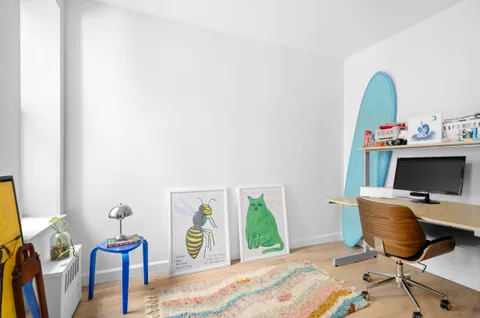 a view of a workspace with furniture and a window