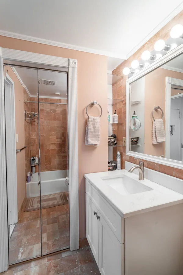 a bathroom with a shower sink and mirror