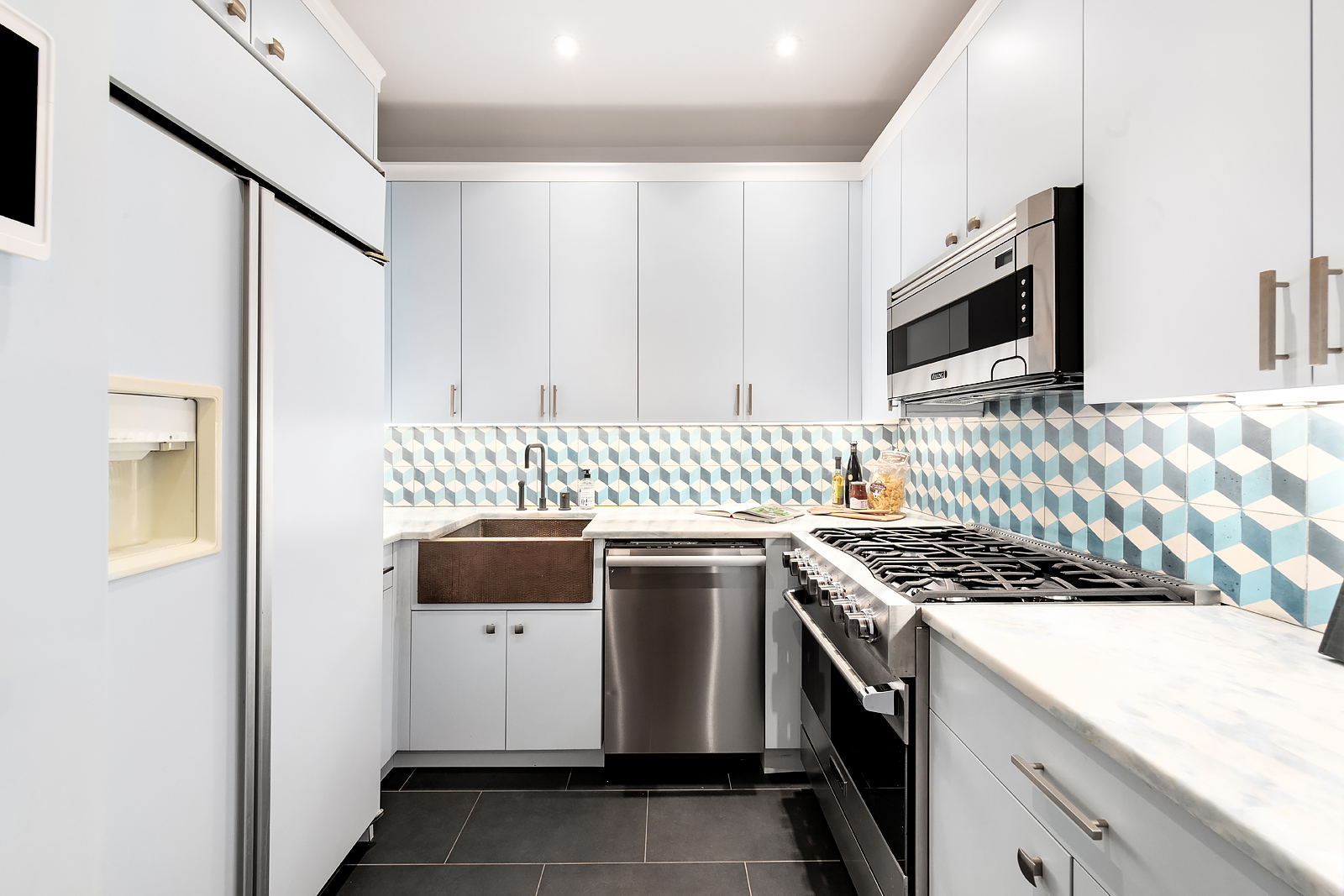 1 Central Park West, Unit 30E Manhattan, NY 10023 - Photo 4 of 12 a kitchen with stainless steel appliances granite countertop a stove and a sink