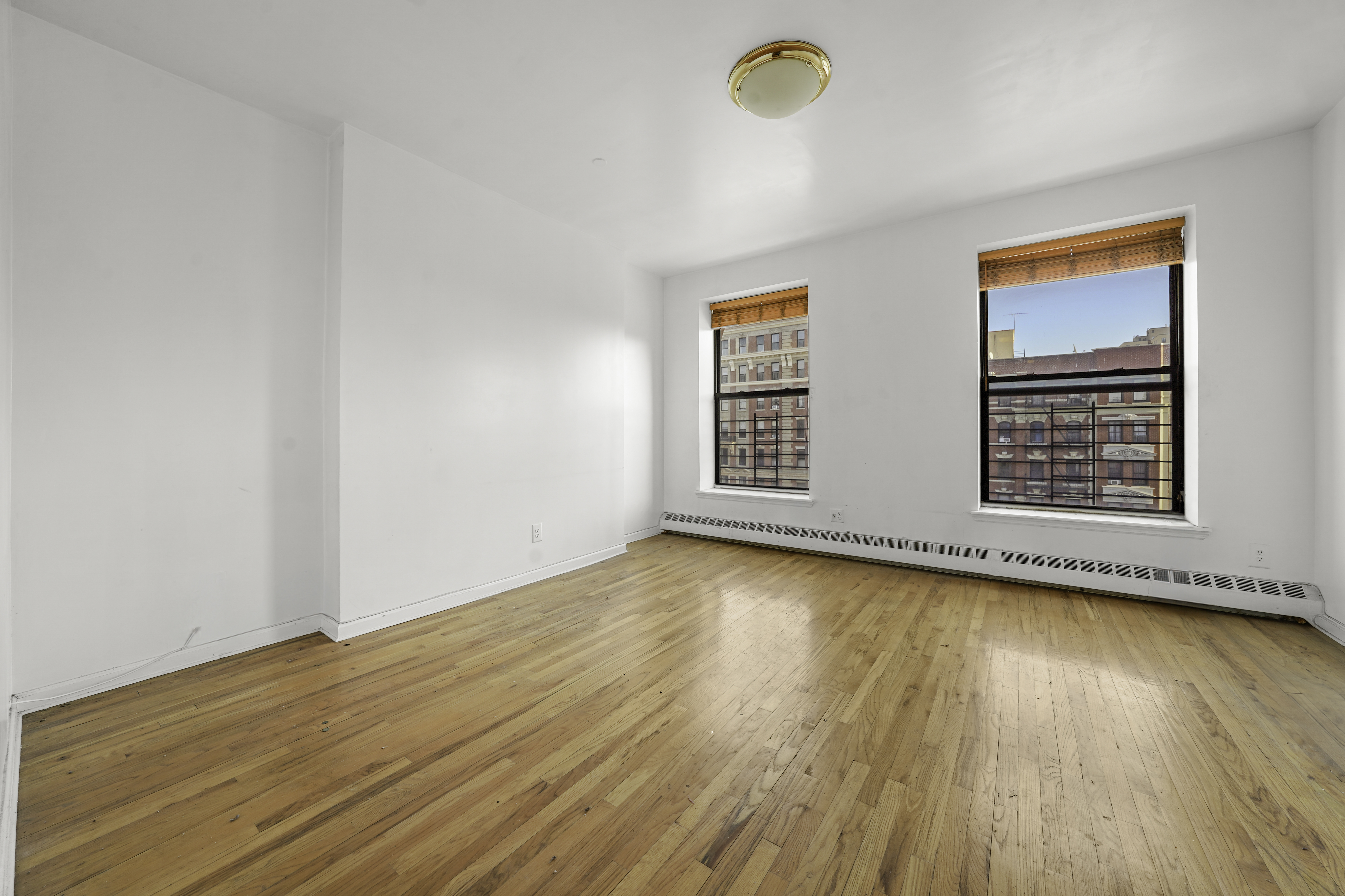 163 Lenox Avenue, Unit 5A Manhattan, NY 10026 - Photo 2 of 16 an empty room with wooden floor and windows