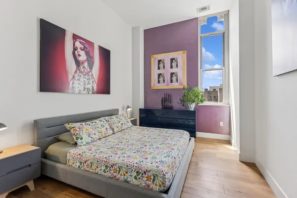 a bedroom with a bed and a painting on the wall