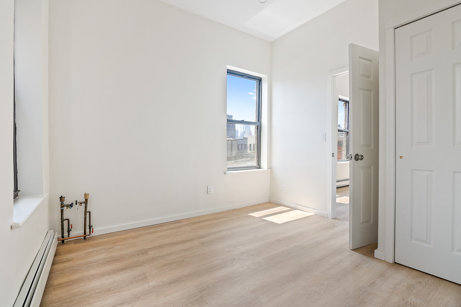108 Stanton Street, Unit 5D Manhattan, NY 10002 - Photo 4 of 6 a view of an empty room with wooden floor and a window