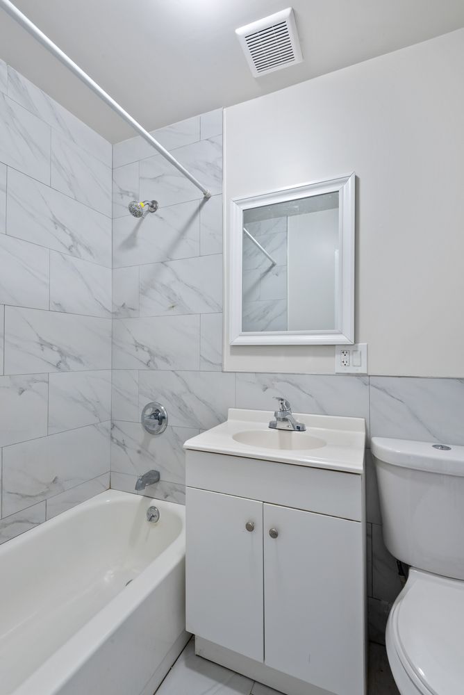 269 Ainslie Street Brooklyn, NY 11211 - Photo 7 of 22 a bathroom with a sink toilet vanity and bathtub