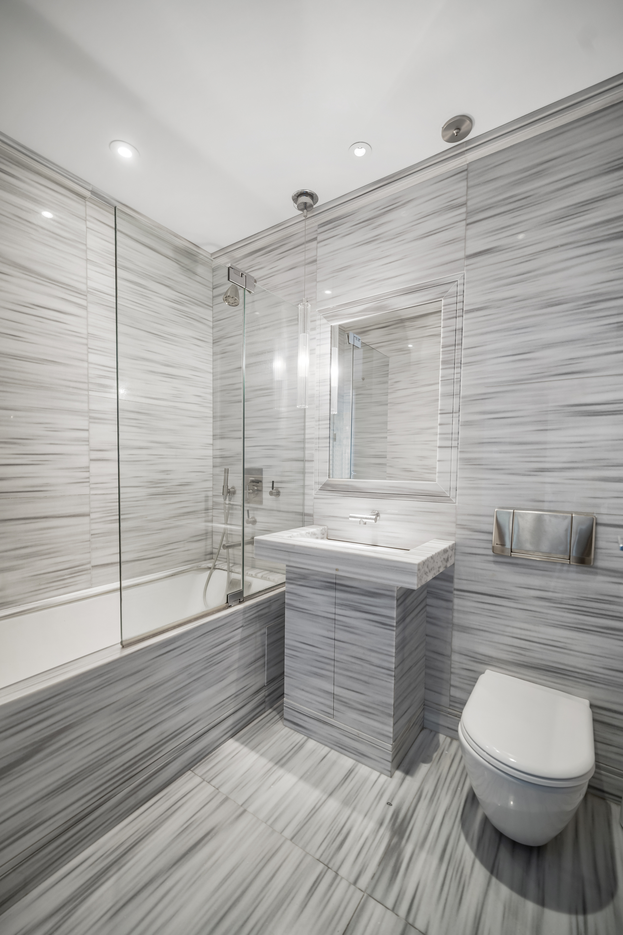 80 Columbus Circle, Unit 67B Manhattan, NY 10019 - Photo 8 of 16 a bathroom with a sink a toilet and shower