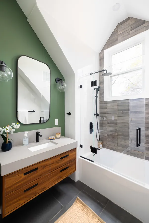 a bathroom with a double vanity sink mirror and bathtub