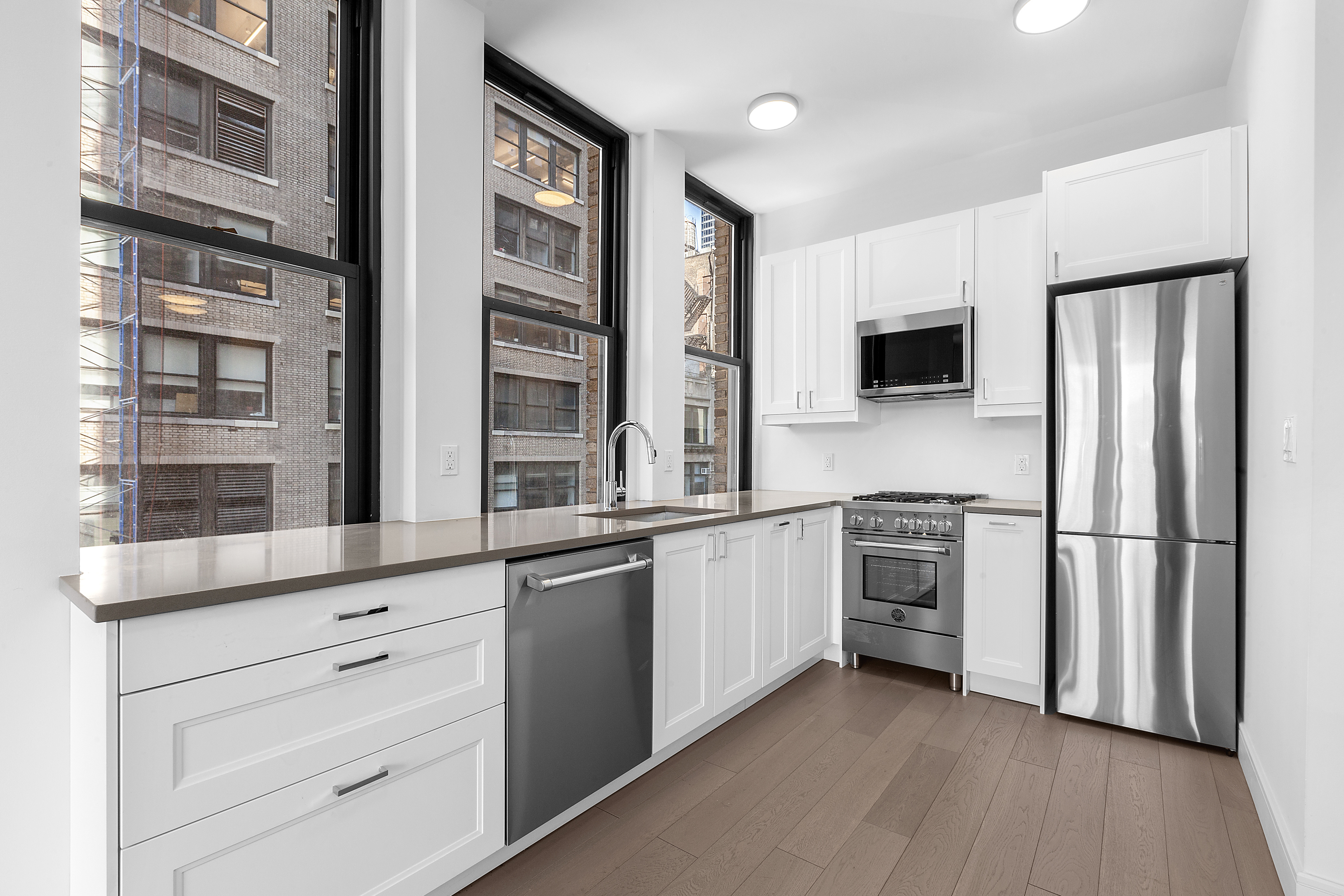 315 7th Avenue, Unit 8A Manhattan, NY 10001 - Photo 2 of 7 a kitchen with stainless steel appliances a refrigerator and a stove top oven