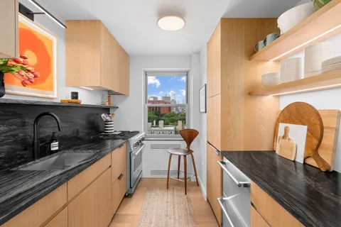 a kitchen with granite countertop a stove a sink and a microwave